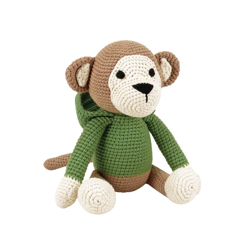 Handgehaakte knuffel 'Sebastian the Monkey' van Woolie, zittend tegen een witte achtergrond, met een bruin-witte vacht en een groen gebreid truitje met capuchon.